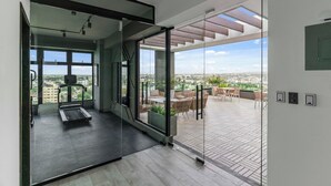 Un interior moderno con un muro de cristal que da a un patio exterior.