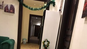 Een moderne keuken met een glazen tafel, stapels papieren borden en koffiekopjes. In de achtergrond staat een kleine kerstboom met versieringen.