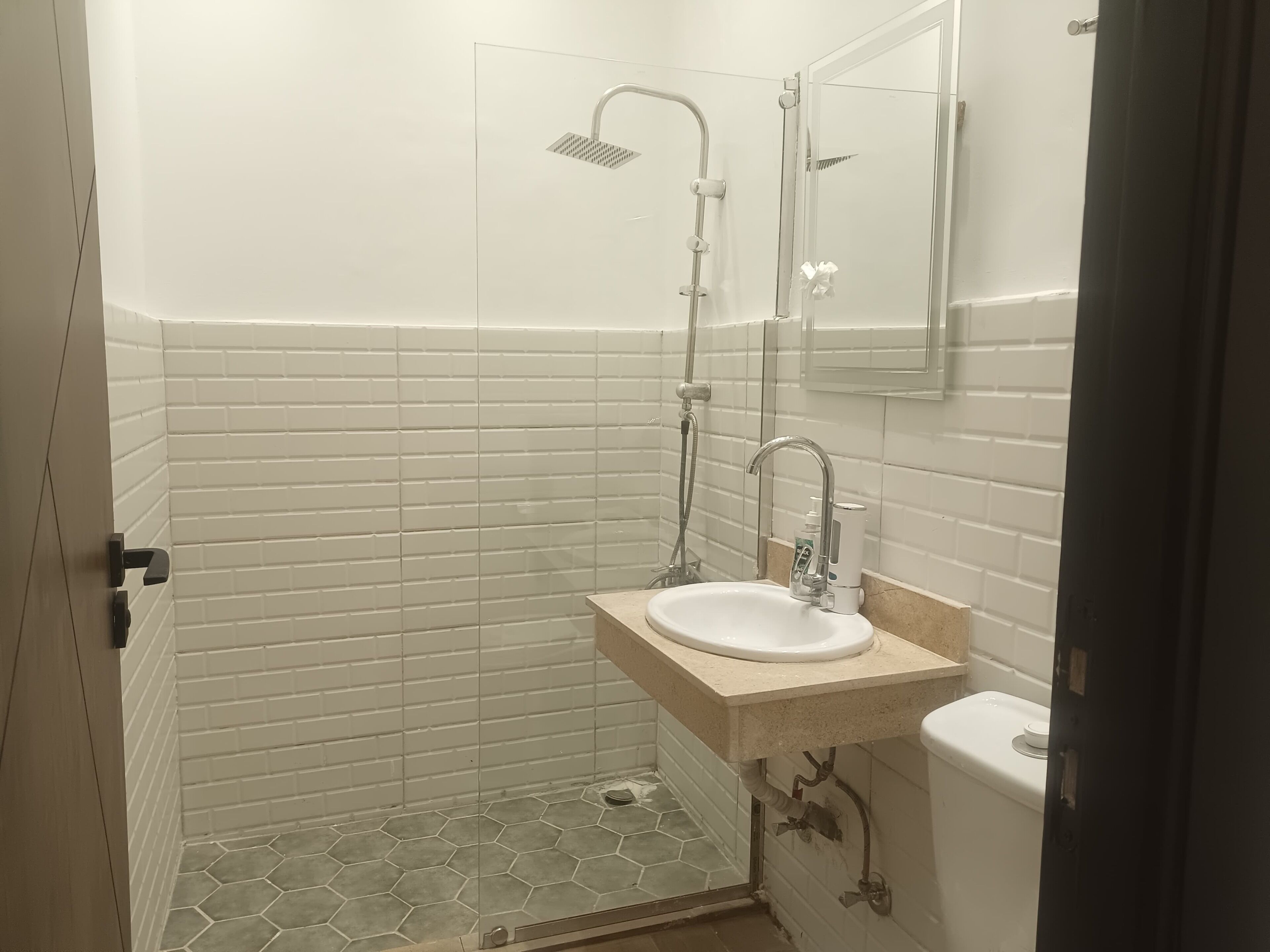 A bathroom with a white sink, a shower, and a toilet.