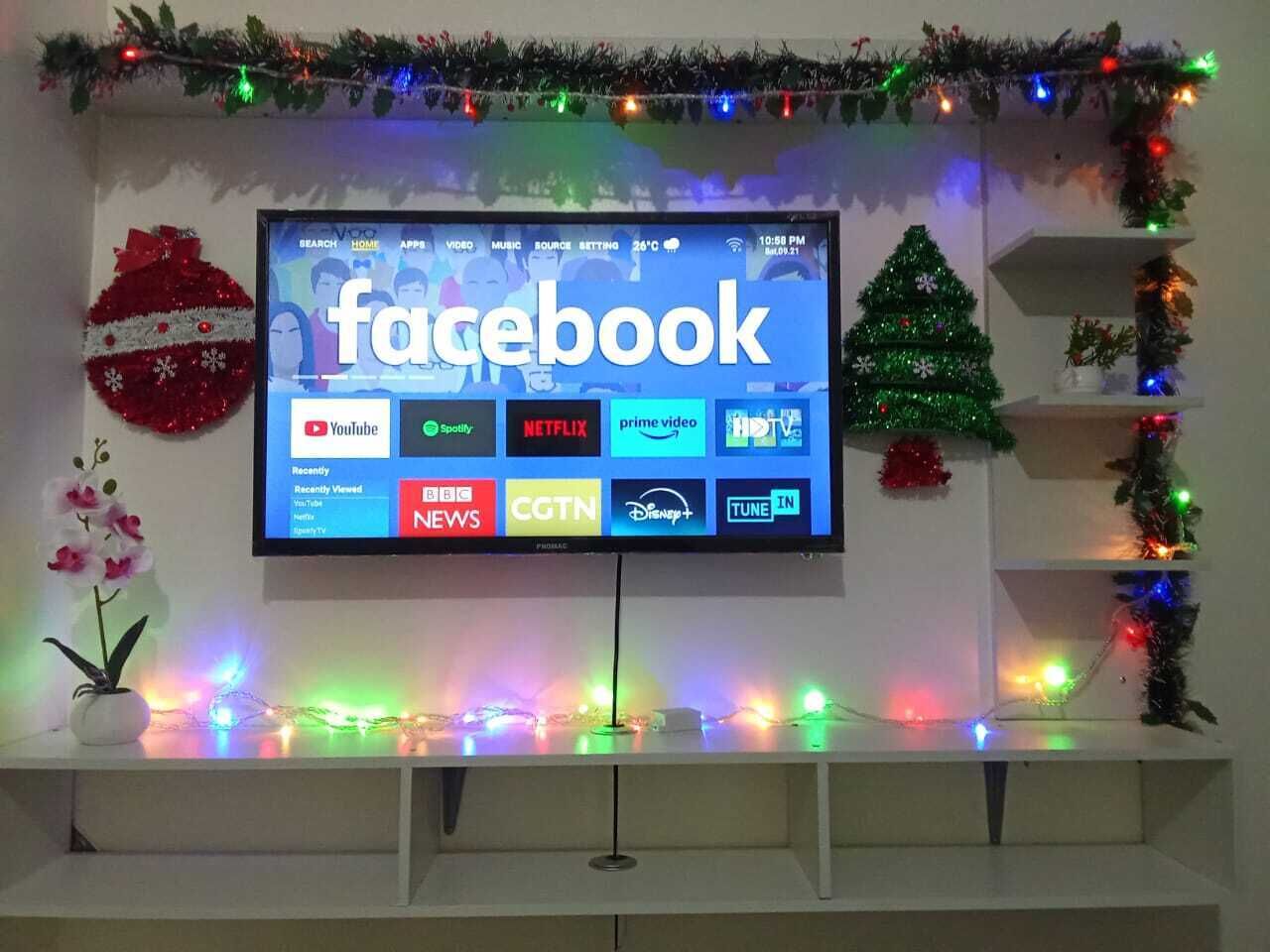 A television displaying the Facebook homepage with various streaming service logos.