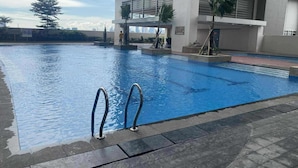 A swimming pool with metal handrails, surrounded by a tiled deck. - 1BR Covent Garden South Tower University Belt- SM Sta Mesa, Metro Manila,Philippines (Manila)