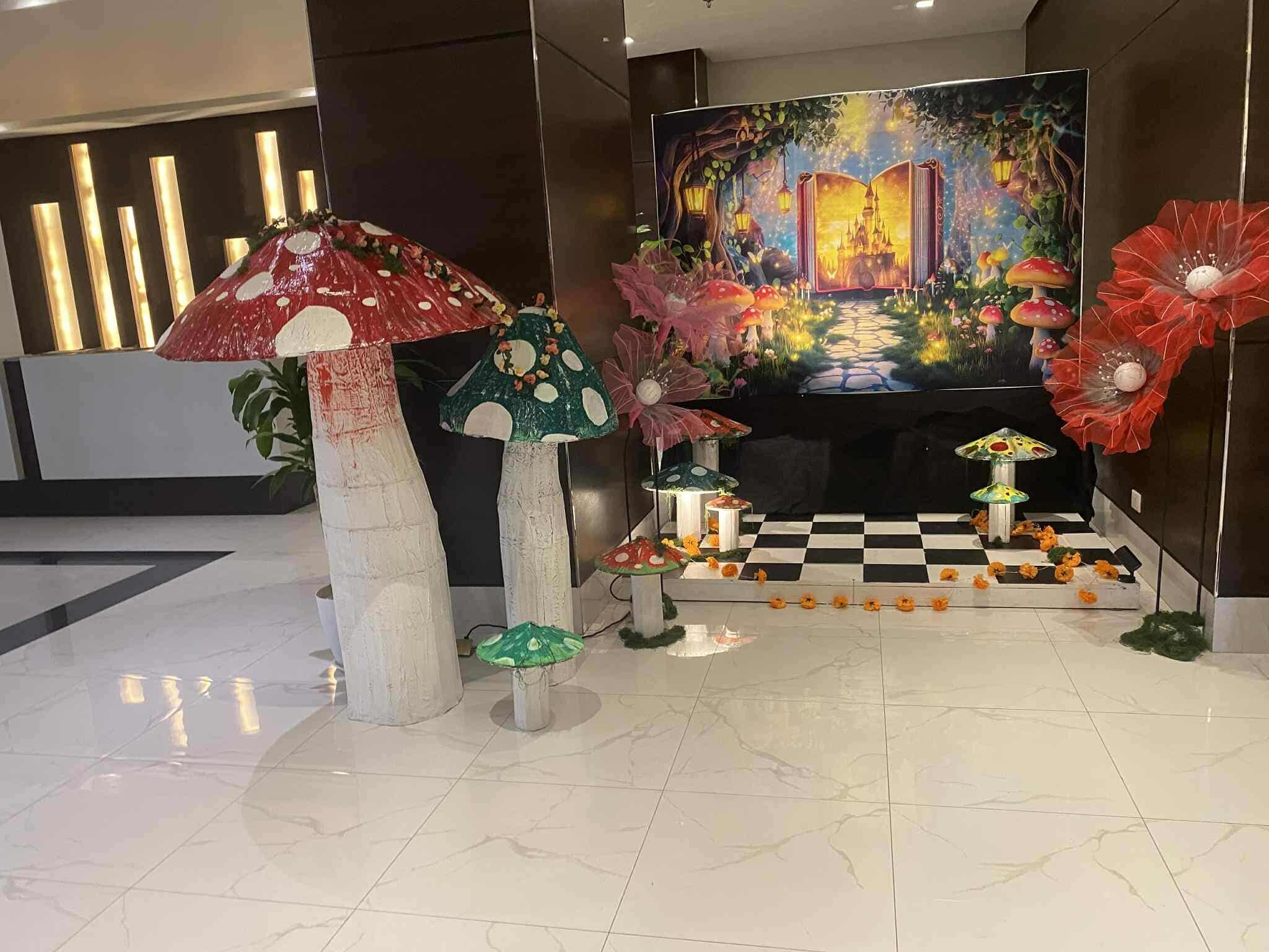 A lobby with a checkered floor, a large mural, and decorative mushroom sculptures.