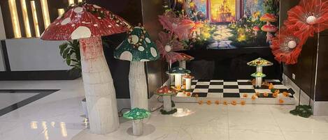 A lobby with a checkered floor, a large mural, and decorative mushroom sculptures.