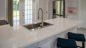 A kitchen with a large island, stainless steel appliances, and a view to the outdoors. - Spacious 3BR Home 2 Baths Amazing Pool Area (Wilton Manors)
