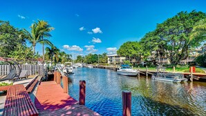 A marina with wooden docks, boats, and a clear blue sky. - Citrus Isles Waterfront Home (Fort Lauderdale)