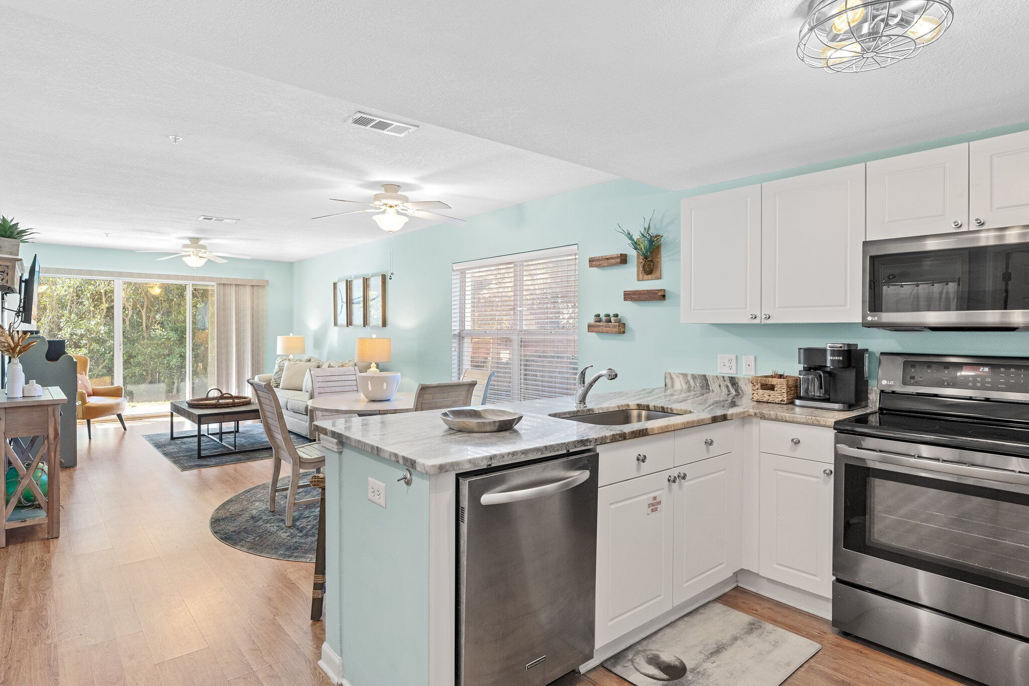 A modern kitchen with white cabinets, a stainless steel oven, and a built-in microwave.