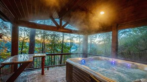 A hot tub with a view of a forested landscape, a wooden deck, and a table with a glass top. - *Private Island*w/ free kayaks, hot tub and VIEWS! (Smithville)