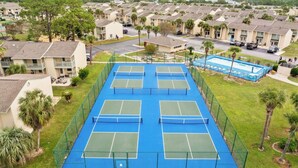 A residential area with multiple apartment buildings, a tennis court, and a swimming pool.
