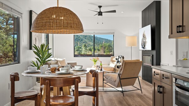 Une cuisine moderne avec un coin repas, de grandes fenêtres et un ventilateur de plafond.