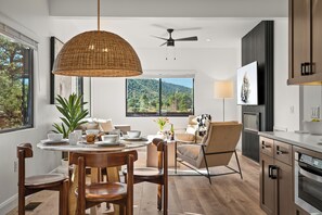 Cozinha moderna com área de refeições, janelas amplas e ventilador de teto.