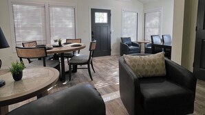 A spacious living area with a dining table, chairs, a sofa, and a fireplace.