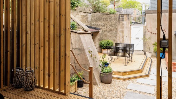 A wooden deck with a hot tub, outdoor seating, and a view of the backyard. - Beachside paradise with hot tub and outdoor shower in Lyme Regis, Dorset (Lyme Regis)