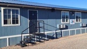 A single-story building with a blue exterior, a front door, and a set of stairs leading to a porch. - 069A Private Studio nr South Rim Sleeps 4 (Williams)