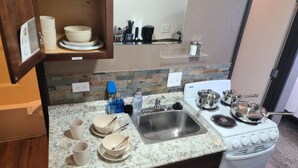 A compact kitchen with a granite countertop, stainless steel sink, and a white gas stove. - 069A Private Studio nr South Rim Sleeps 4 (Williams)