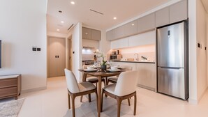 A modern kitchen with a dining area, stainless steel appliances, and a neutral color palette.