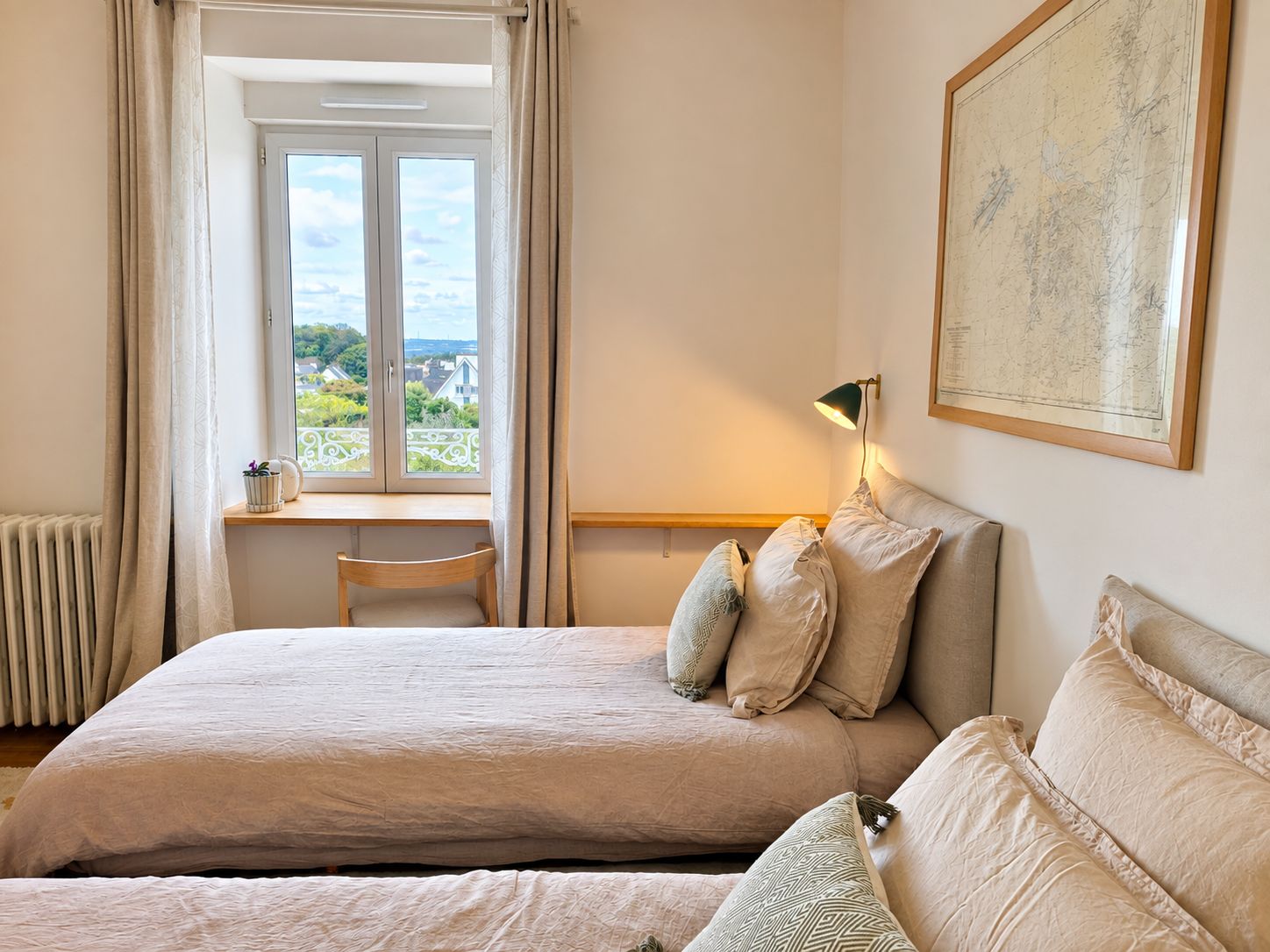 Une chambre à coucher avec un lit, un bureau et une fenêtre donnant sur un beau paysage.