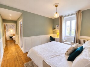 A bedroom with a large bed, a desk, and a window with curtains. - Les Chambres D'Hespéris (Pleyben)