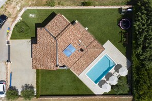 A rooftop with a swimming pool, a covered patio, and a small garden area.