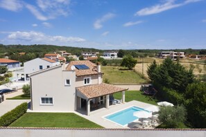 Un quartier résidentiel avec des maisons modernes, une piscine et un ciel dégagé.