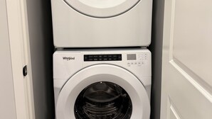 Una lavadora y secadora apiladas en un cuarto de lavado.