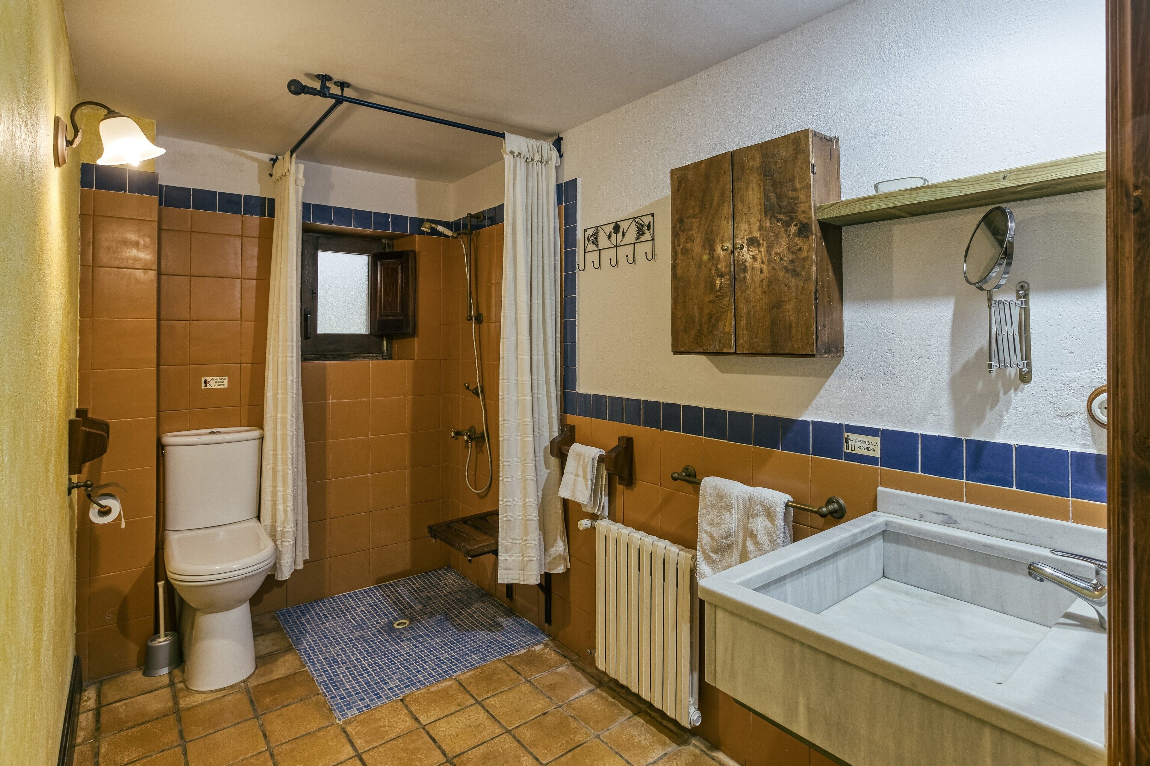 A bathroom with a toilet, shower, and sink.
