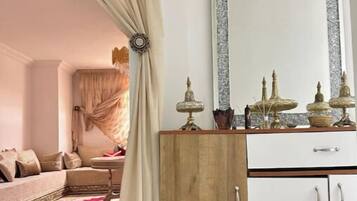 Una habitación con sofá, un armario de madera y un espejo.
