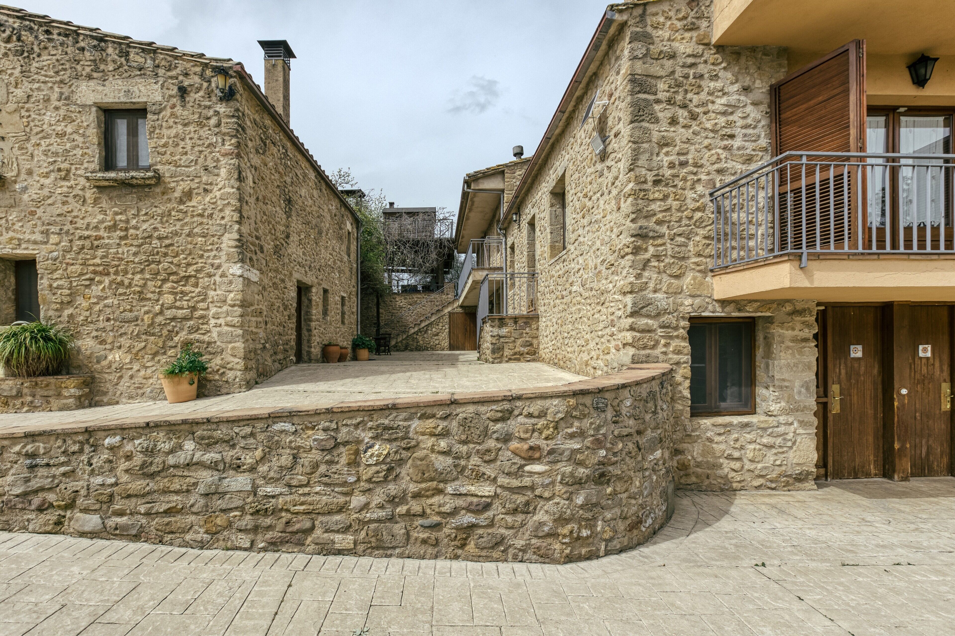 A stone building with a balcony, a door, and a window.