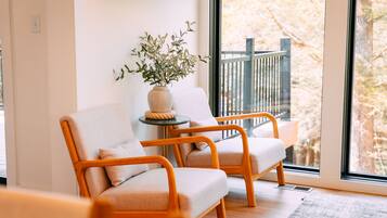 A room with two chairs, a small table, and a potted plant.