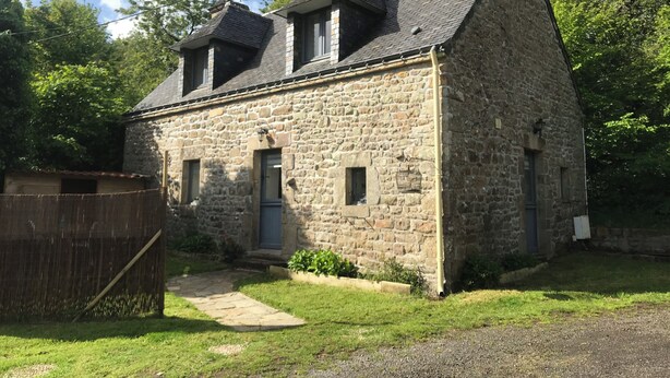 A stone building with a sloped roof, two small windows, and a wooden fence. - Breton cottage in the countryside, calm & comfort (Locoal-Mendon)