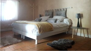 A bedroom with a bed, a bedside table, a lamp, and a rug.