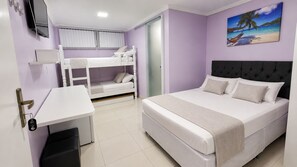 A bedroom with bunk beds, a bed, a desk, and a painting of a beach scene. - Alice Suites (Arraial do Cabo)