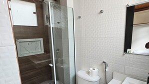 A bathroom with a glass-enclosed shower, a toilet, and a sink. - Alice Suites (Arraial do Cabo)