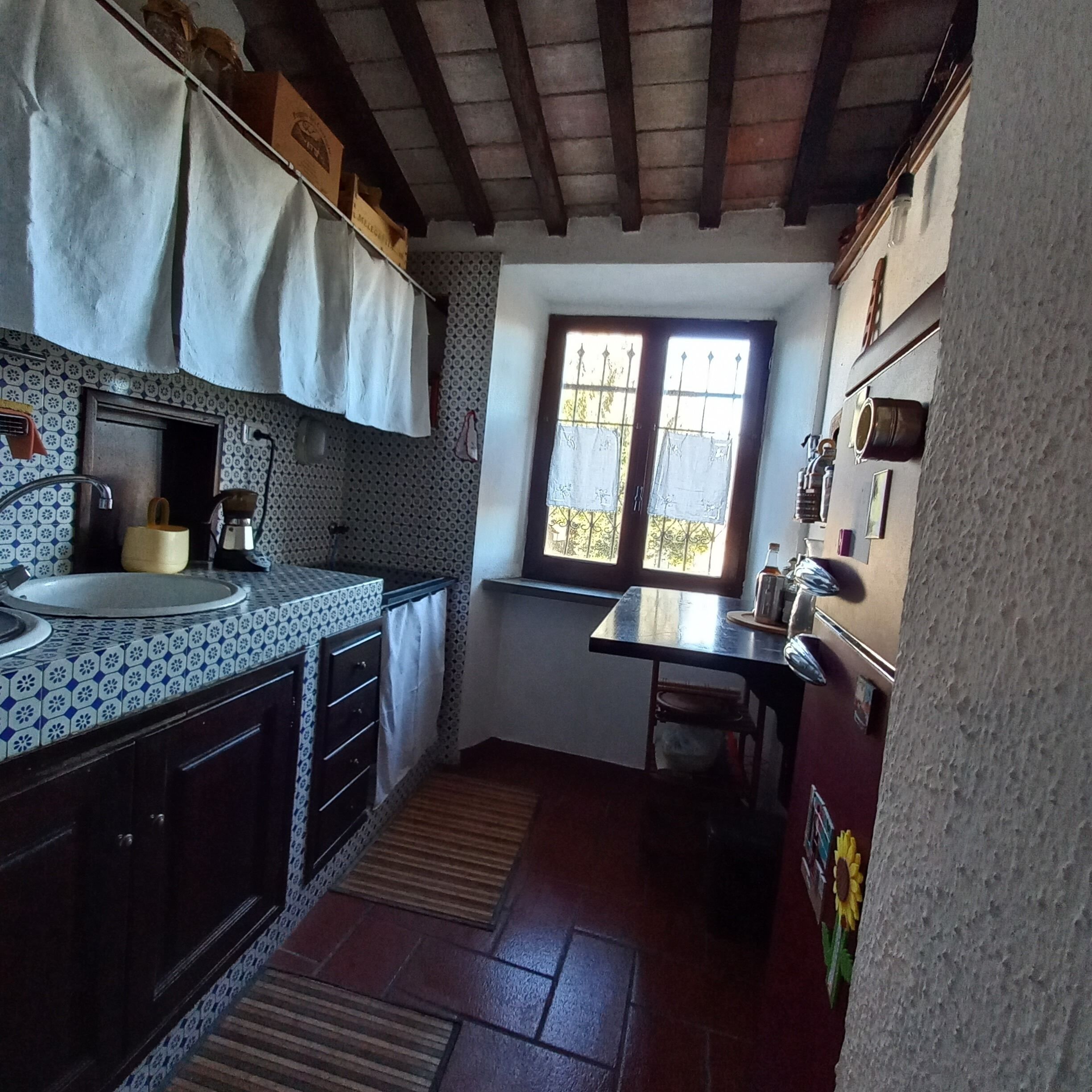 A compact kitchen with a sink, cabinets, and a window.