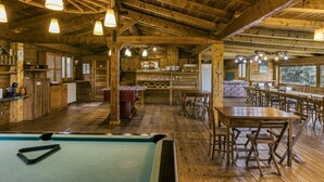 A wooden interior with a pool table, dining area, and kitchen. - Room 'Tramuntana' with Shared Pool, Wi-Fi and Air Conditioning (Girona)