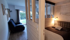 Una camera da letto con un letto, un comodino, una lampada e una finestra vista all'esterno.