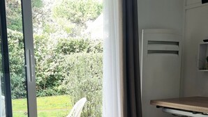 Una stanza con un tavolo, un cesto e una sedia vicino a una porta scorrevole in vetro.