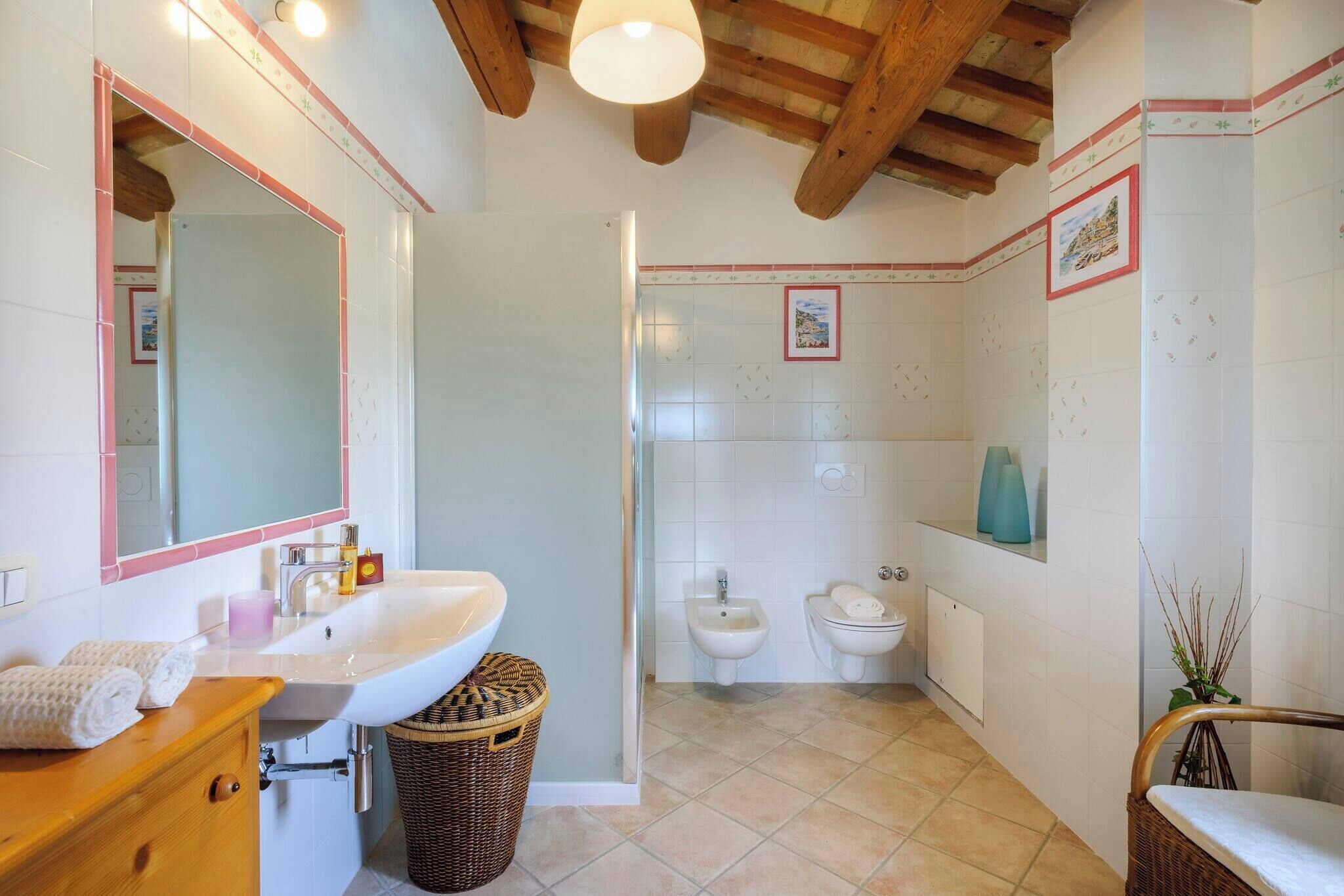 Baño con lavamanos, espejo y dos inodoros.