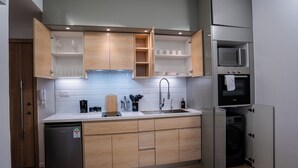 Une cuisine compacte avec des meubles en bois, un four à micro-ondes encastré et un lave-vaisselle.