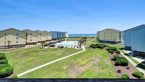 A hotel with multiple buildings, a swimming pool, and well-maintained lawns. - NEW 2025 Cozy 1-bedroom condo in awesome Surf City with WiFi, AC (Surf City)