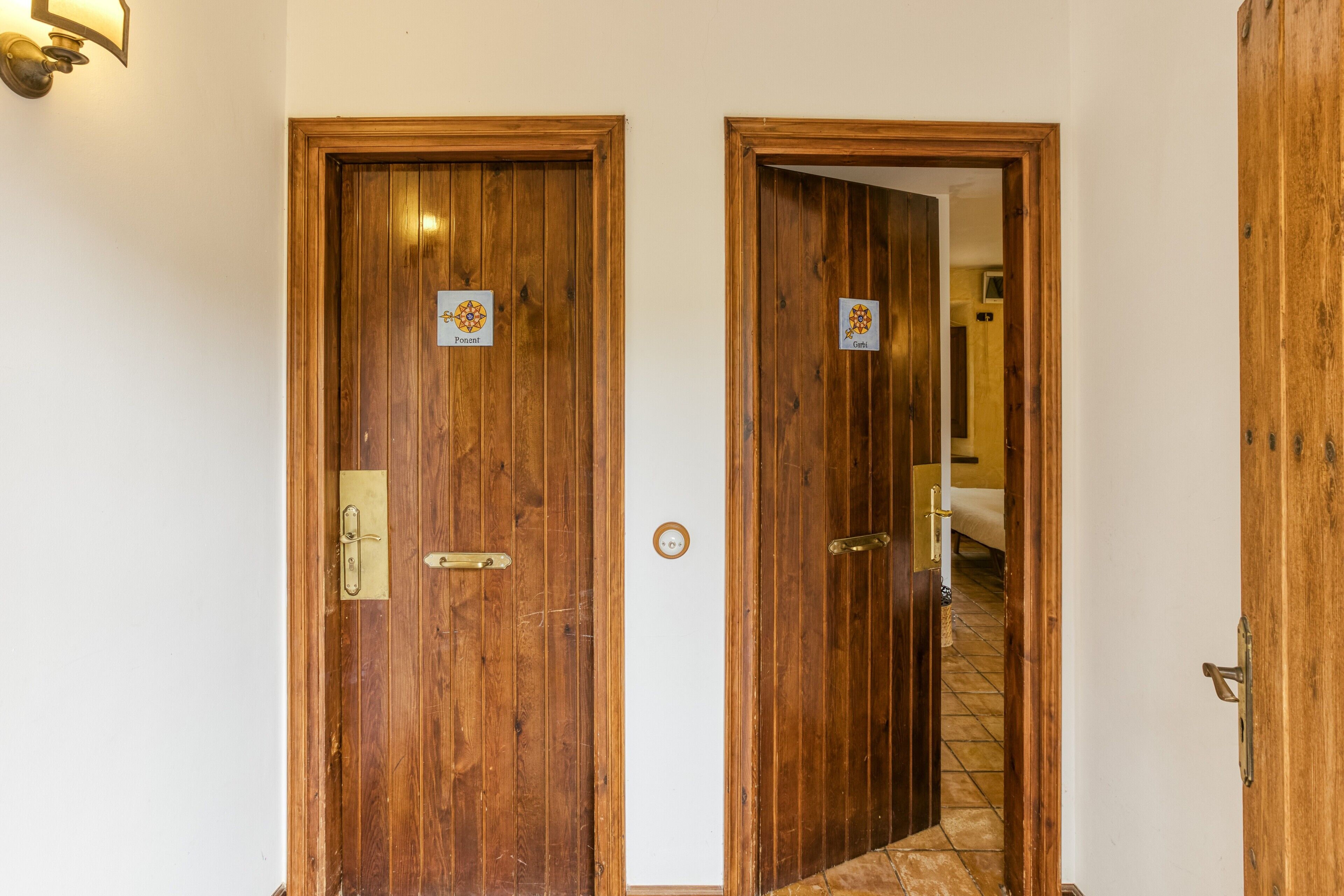 Two wooden doors with brass handles and a small sign above each door.