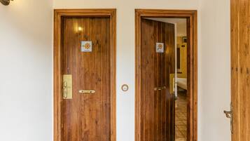 Two wooden doors with brass handles and a small sign above each door.