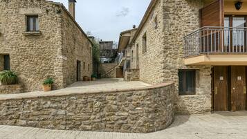 Un edificio de piedra con un balcón, una puerta y una ventana.