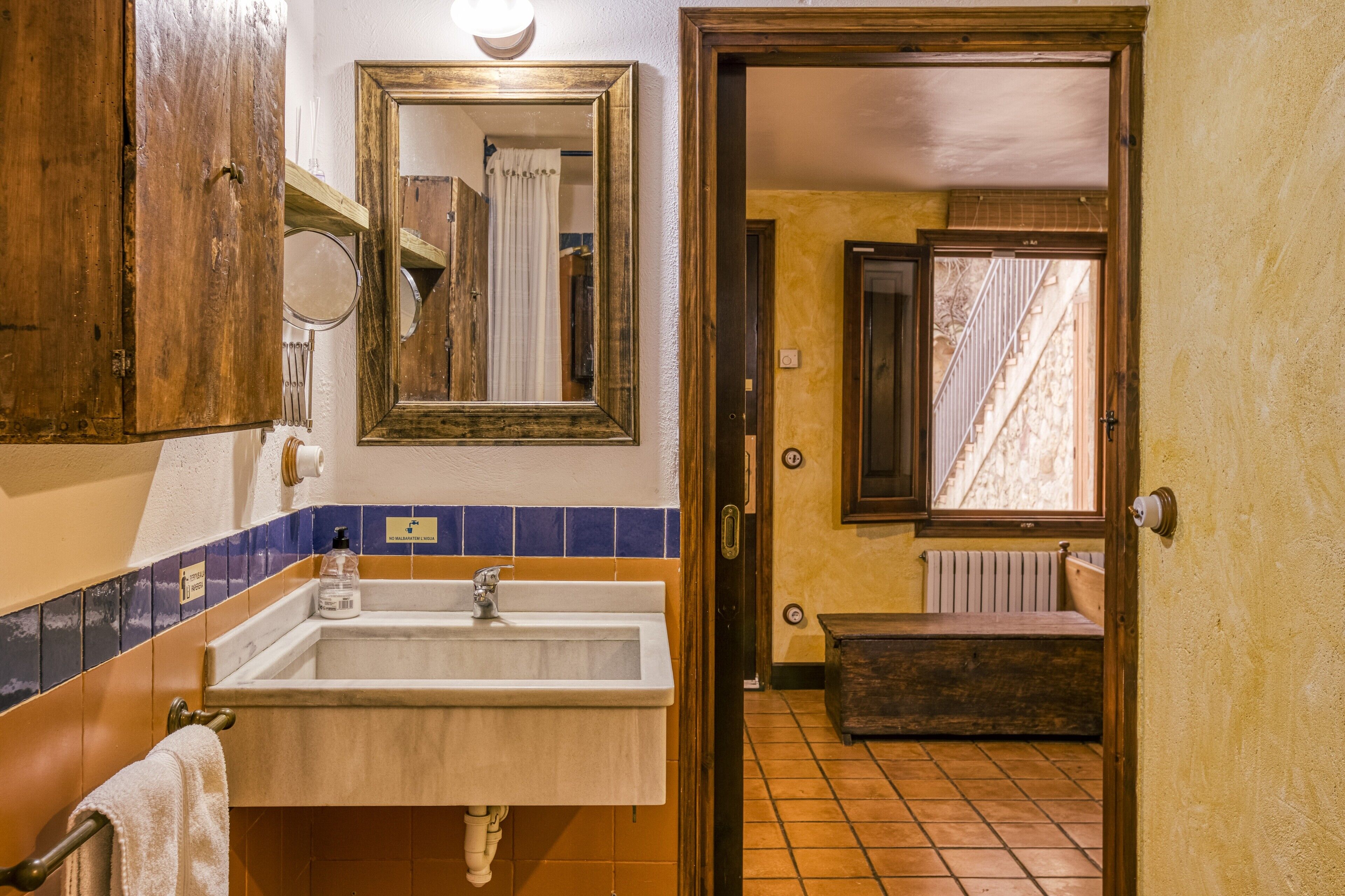 A bathroom with a sink, mirror, and wooden cabinets.