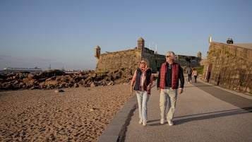 Un camino costero con una fortificación de piedra al fondo.