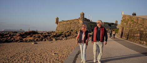A coastal walkway with a stone fortification in the background.