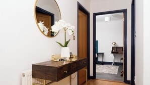 A modern bathroom with a wooden vanity, a white orchid vase, and a round mirror. - Ramsgate boutique  (Ramsgate)