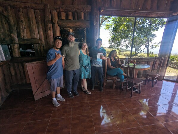 Un interior rústico de madera con suelo de baldosas, una mesa de madera y sillas.