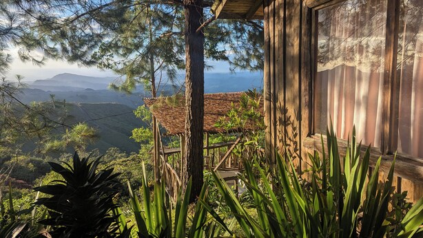 Una cabaña de madera con vistas a un paisaje montañoso.