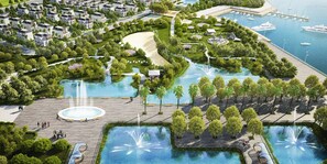 An aerial view of a resort with multiple swimming pools, a marina, and a variety of trees and pathways.