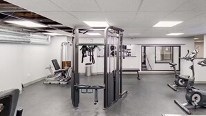 A gym with various exercise equipment, including a squat rack, bench press, and treadmills. - Killington Sapphire (Killington)
